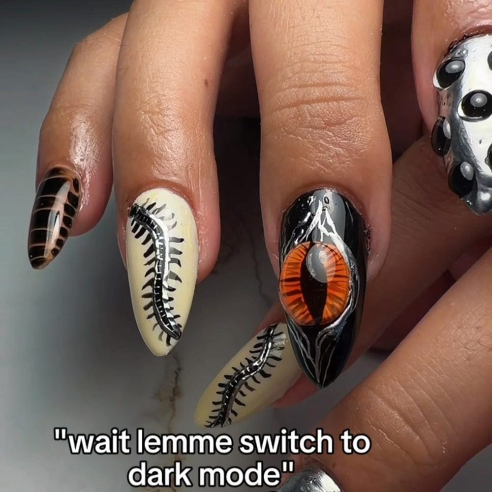 Dark custom nail art with a hand-painted eye design