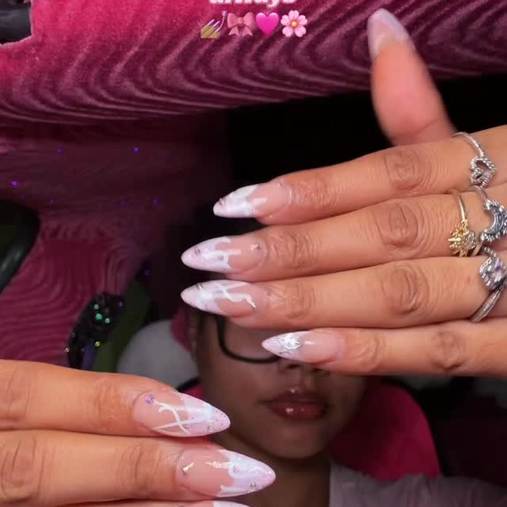 Pink Gel-X almond nails with white swirl art